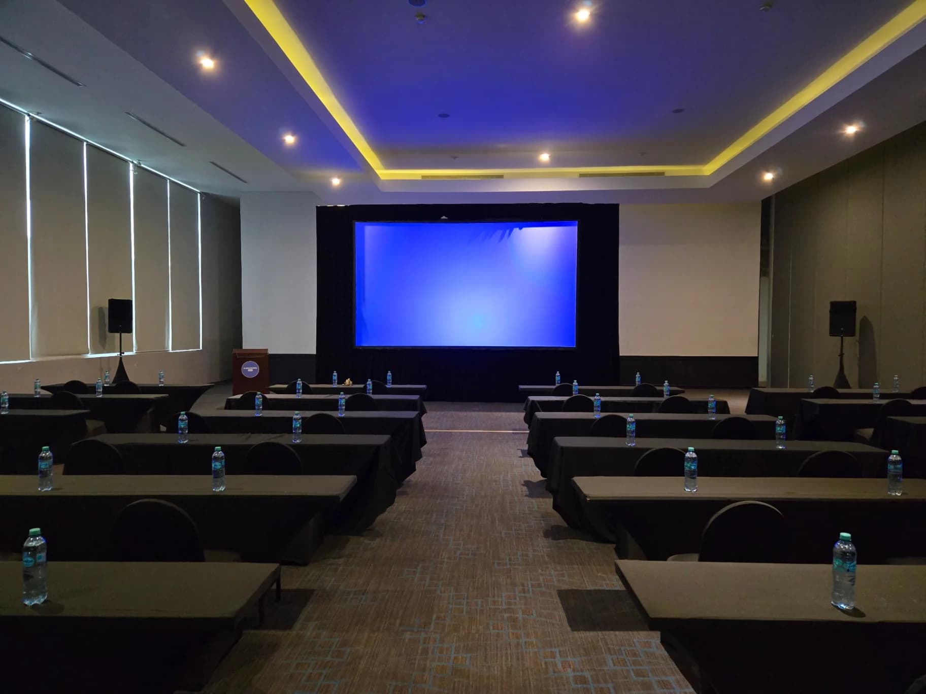 Conference room set with tables, chairs, and a projection screen